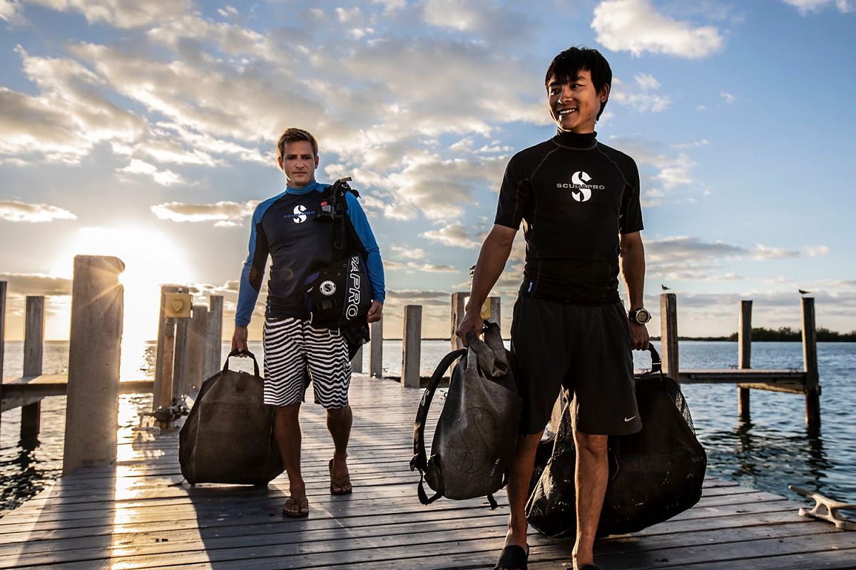 Two SCUBA divers walking on the dock