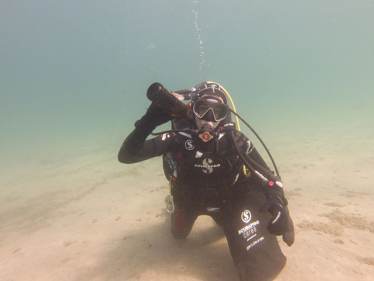 SCUBA diver picks up trash under water